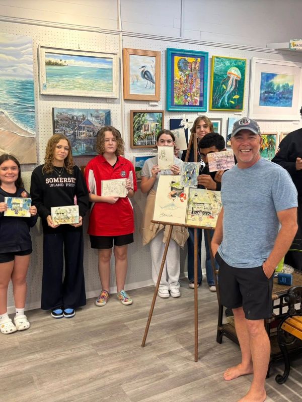 A group of young artists displaying their artwork in a gallery.