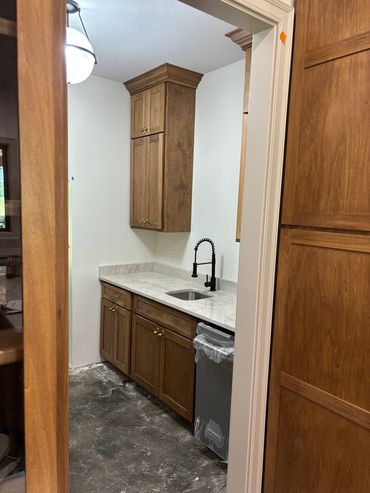 Kitchen with wooden cabinets and a small sink.