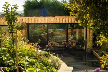 Cozy garden retreat with wooden exterior and lush greenery.