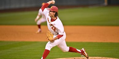 Baseball pitcher mid-throw on the mound during a game.