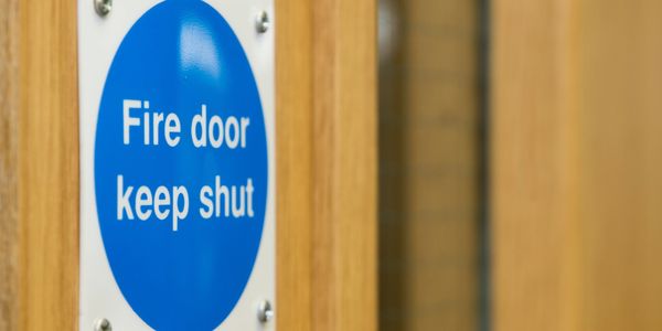 Close-up of a fire door sign instructing to keep shut.