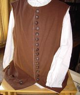 Plain waistcoat in brown linen with horn rimmed buttons and flap pockets.