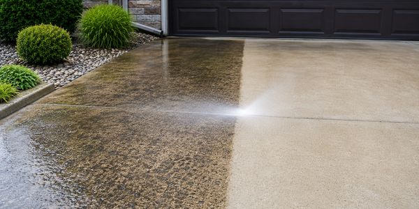 Pressure washing a driveway, showing a clear clean line.