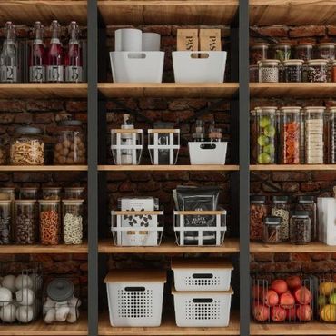 Organized pantry shelves with jars, baskets, and containers against a brick wall.