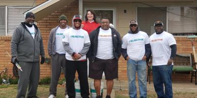 Group of people posing in front of a house.