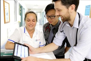 Medical team reviewing patient information on a tablet.