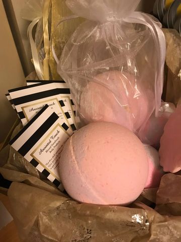 Pink bath bombs and black-and-white striped cards in a gift basket.