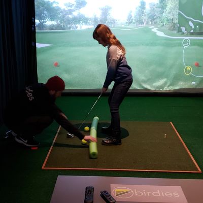 Birdies Professional Patrick Murphy working with a Junior Academy student. 