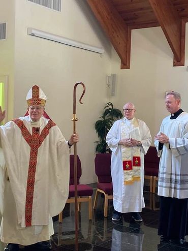 Bishop Gerald Barbarito blesses congregation, with Father Michael and Father Brian King.