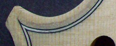 Unfinished guitar body under tension in shaping frame