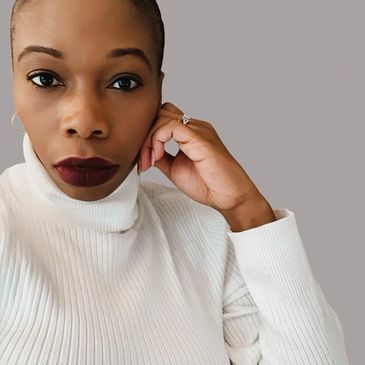 Woman in white turtleneck with dark lipstick.