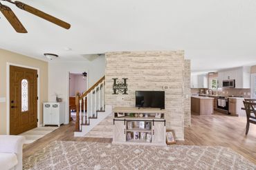Cozy living room with wooden accents and open kitchen layout.