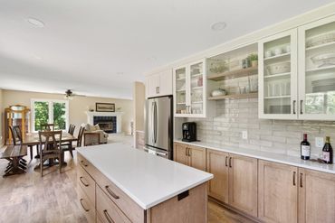 Bright modern kitchen with wooden cabinets and white countertops.