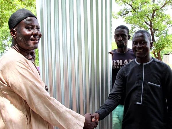 Mion District Planning Officer of  Ghana Education Service Receiving three packets of roofing sheets