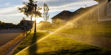 Irrigation sprinklers watering neighborhood front yard's houses  