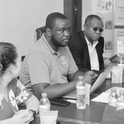 Three people engaged in a serious discussion at a meeting table.