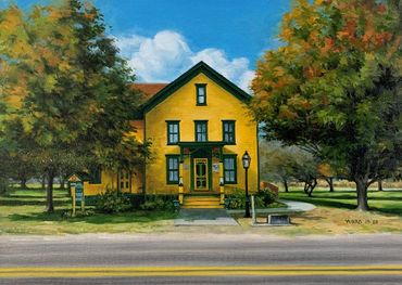 Yellow house surrounded by trees under a partly cloudy sky.