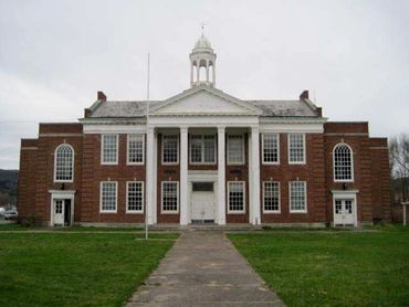 Historic brick building with white columns and windows.