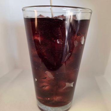 A glass candle resembling a cold drink with ice.