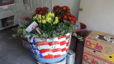 Patriotic mural decorative painting on wine barrel with planted flowers.