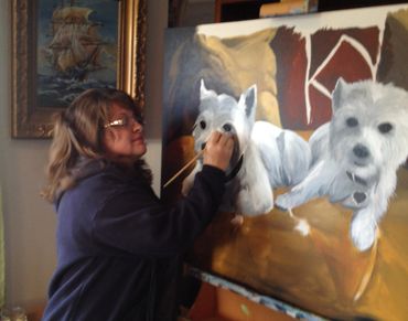 Jill Roberts painting two white dogs on canvas. paintbrush. dogs on couch. Temecula, CA