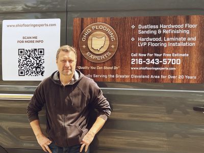 The project manager of Ohio Flooring Experts, Mike, is standing by the company van, ready to start t