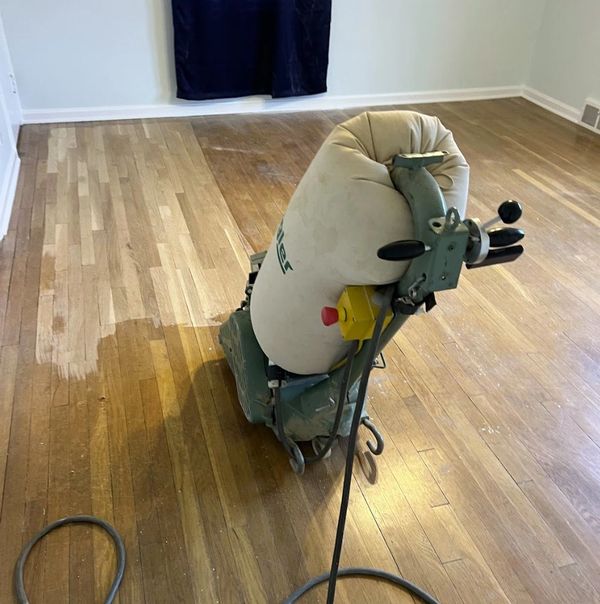 Worn hardwood flooring being sanded in a Beachwood property