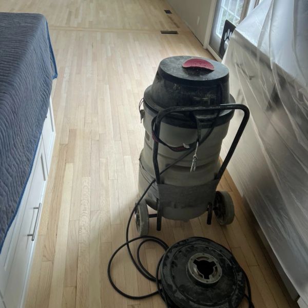 Hardwood floor sanding in process using a commercial-grade HEPA filter vacuum system in a Lakewood,