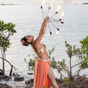 Fire Dancer posing with fire fans on the beach with Tropical Bellydance Costume