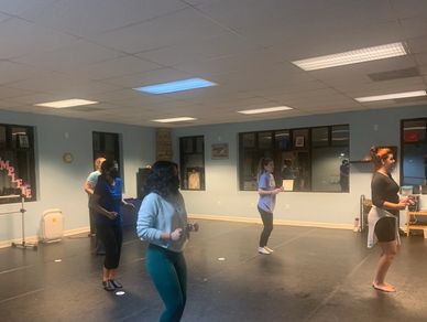 Group of people practicing dance in a studio.