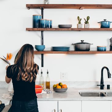 A girl tidying her kitchen and organising her shelves