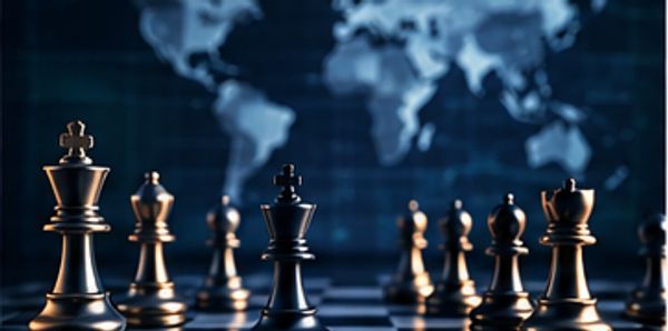 Chess pieces on a board with a blurred world map background.