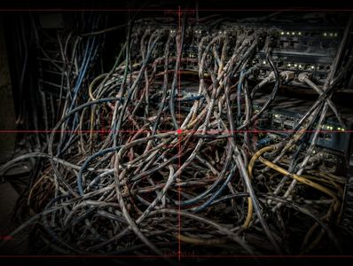 Tangled network cables in a server room.