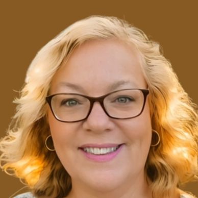 Smiling woman with glasses and curly blonde hair.