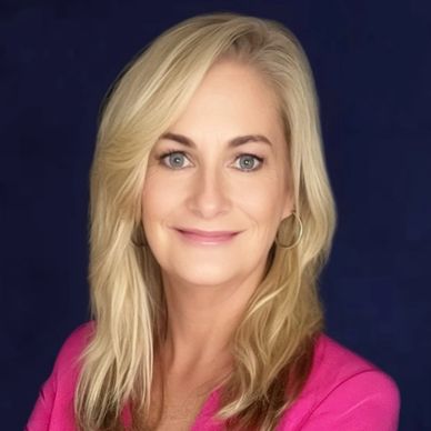 Portrait of a smiling blonde woman with blue eyes.