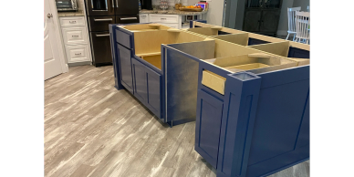 Uninstalled blue kitchen cabinets on wooden floor.