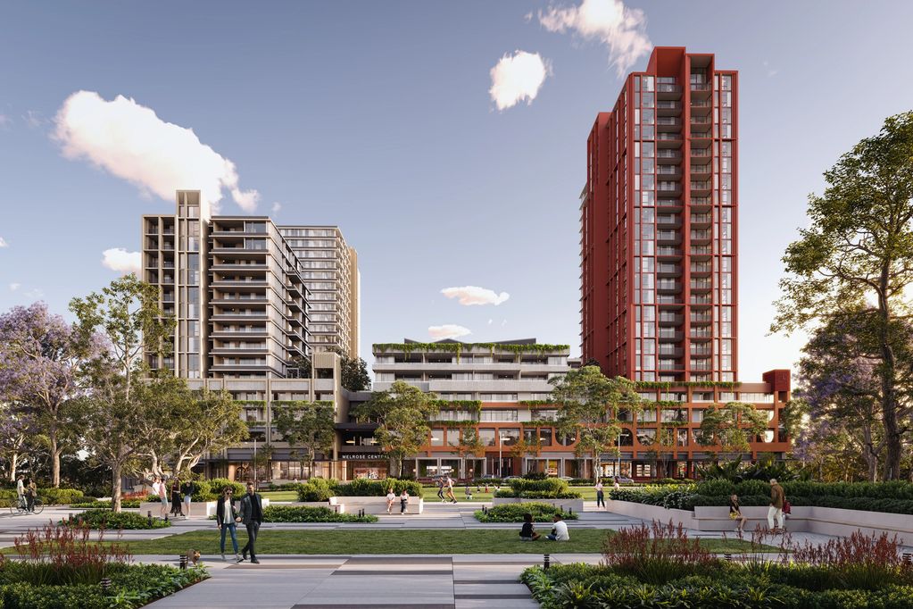 Modern residential buildings with green terraces and people enjoying a park in front.
