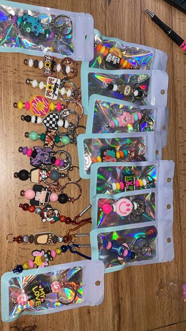 Collection of colorful keychains and charms displayed on a wooden surface.