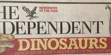 Newspaper headline about dinosaurs featuring T. rex and Triceratops.