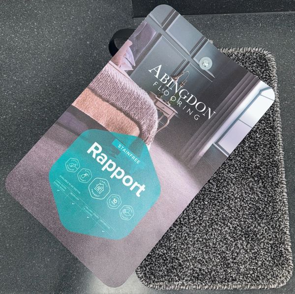 Carpet sample card from Abingdon Flooring showing 'Rapport' stain-free carpet.
