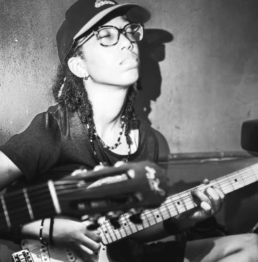 Steph Z playing electric guitar with closed eyes.