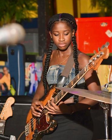 Makalia playing electric bass guitar.