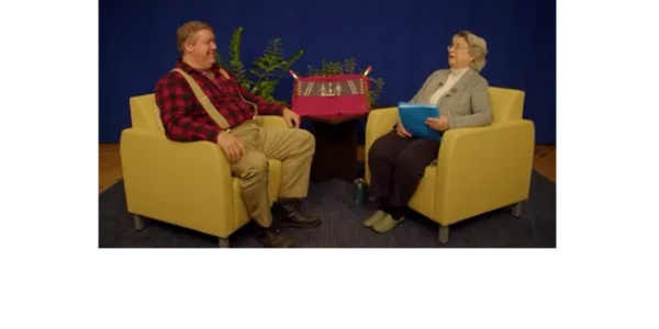 Chief Don Stevens sitting in a yellow chair talking to Juliana Anderson  of Vermont Byways.