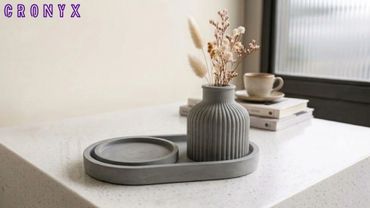 Minimalist grey vase with dried flowers on a modern tray.