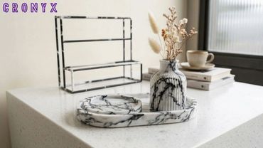 Marble-patterned vase and trays on a white countertop with minimalist decor.
