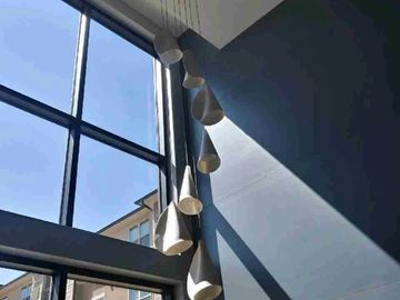window showcasing modern hanging lighting against blue wall