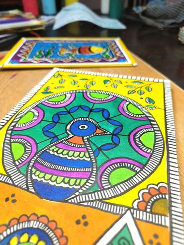 Close-up of colorful, intricate folk art paintings featuring birds and geometric patterns.