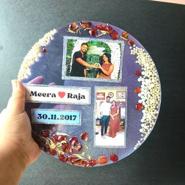 A decorated round plaque with photos and the names Meera and Raja, dated 30.11.2017.