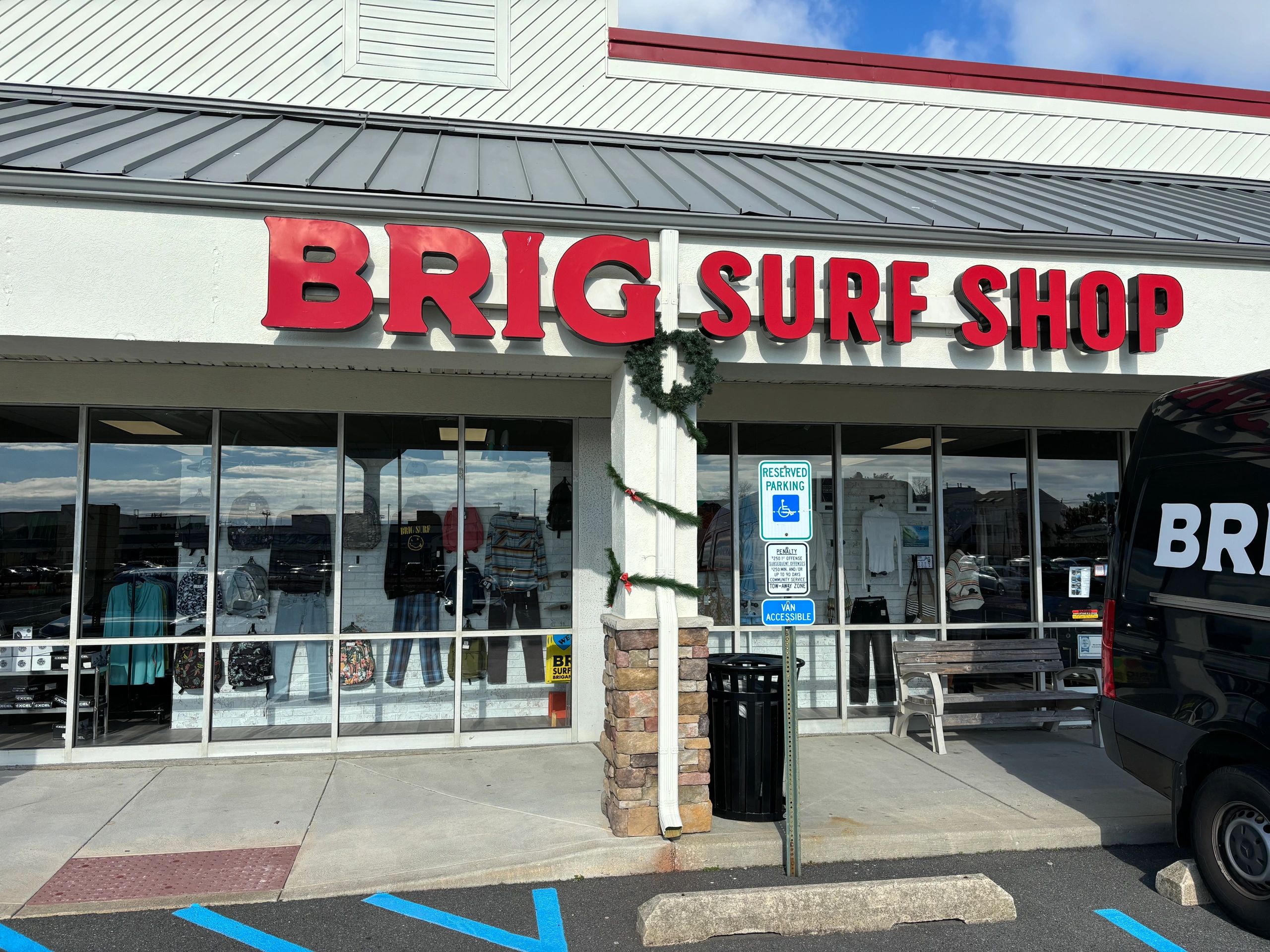 Exterior of Brig Surf Shop with red signage and holiday garland.