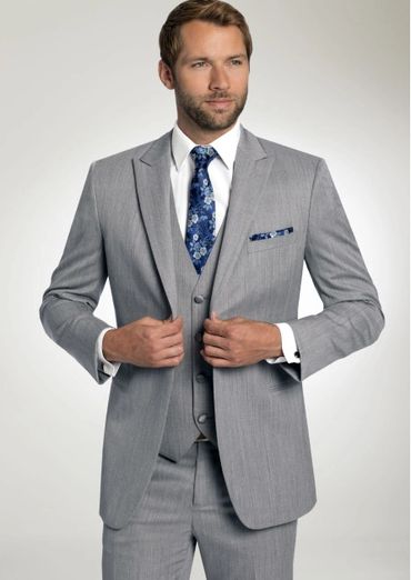 light grey 3 piece suit with white shirt, blue and grey patterned tie and square